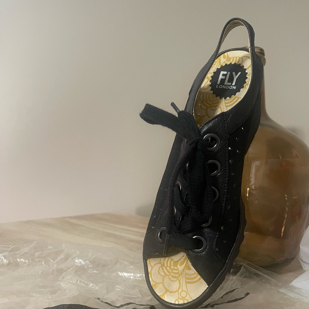 Black leather lace-up Fly London sandal.